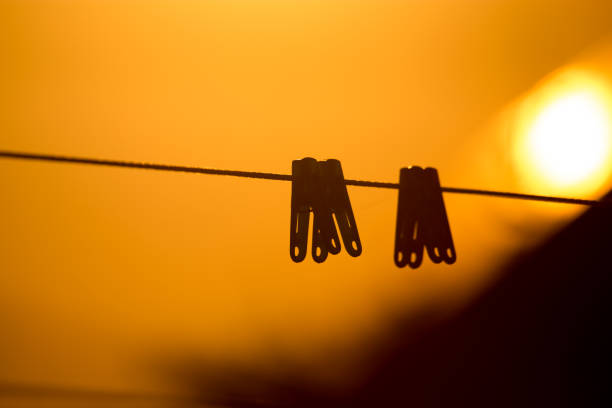 Clothespin on a rope in the rays of sunset .