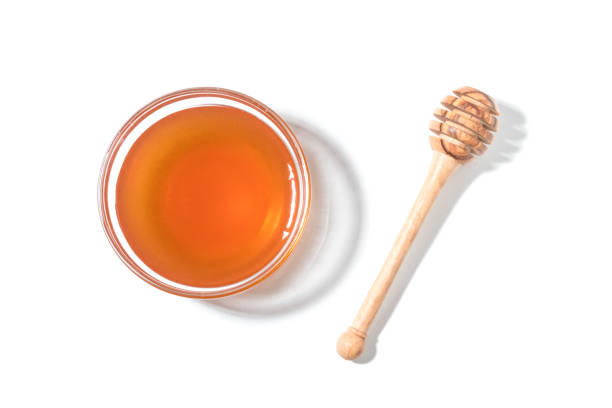 istock Honey dipper and honey in jar on white background. 900298780