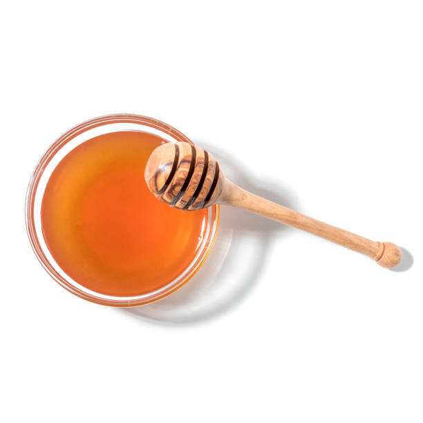 istock Honey dipper and honey in jar on white background. 900298792