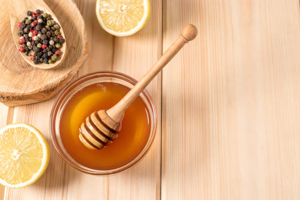 istock Honey with lemon and spice on a wooden background. 900298912