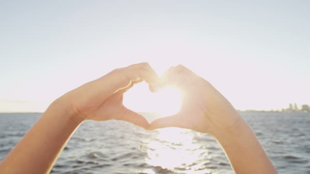 Heart shaped hands showing ocean social networking greeting