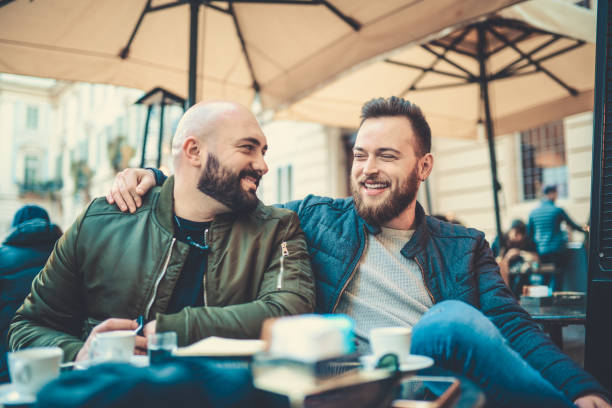 dwóch uśmiechniętych przyjaciół pijących kawę i rozmawiających w kawiarni - couple outdoors coffee friendship zdjęcia i obrazy z banku zdjęć