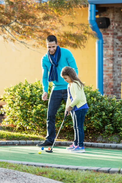 istock Father and daughter playing miniature golf 900314714