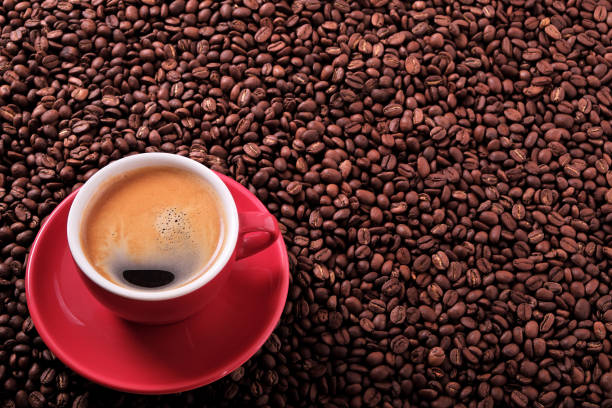 istock Red coffee cup with espresso and roasted beans background 900321692