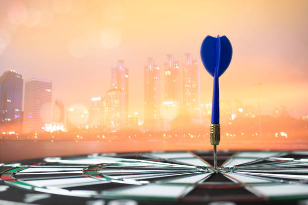 istock dart on board with  city scape background, concept as success and goal 900331134