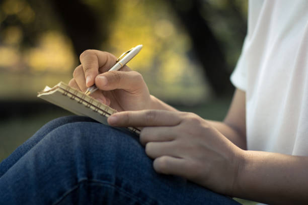 istock close up young women writing on notebook in park, concept in education and knowledge 900331148
