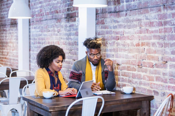 istock Young couple working on computer in coffee shop 900341906