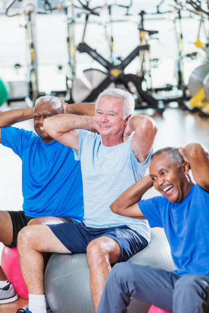 istock Three multi-ethnic senior men in gym exercising 900348296