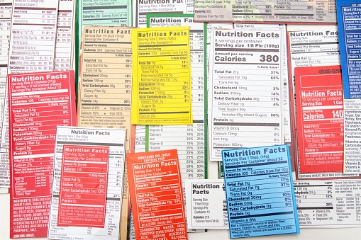 Nutrition label collage of multiple packaging labels. Nutrition facts show quantities of ingredients in products, including calories, fat, saturated fat, sodium, sugar, protein, carbohydrates, fiber and vitamins