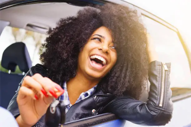 big smile, afro hair girl with beautiful bright teeth. stylish black girl happy sitting in her car