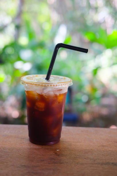 istock Black ice coffee on table with blur nature background 900378158