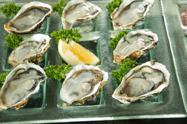 istock Oysters on glass plate with spicy sauce 900392492