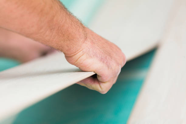istock Installing laminate floor with wooden texture 900392710