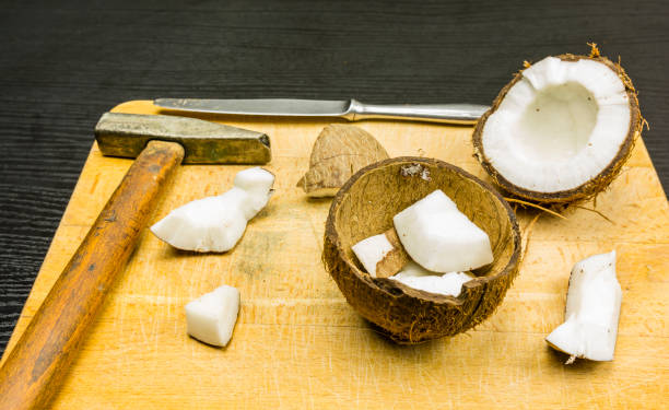 istock Open and divided coconut with tools used at home. 900399408