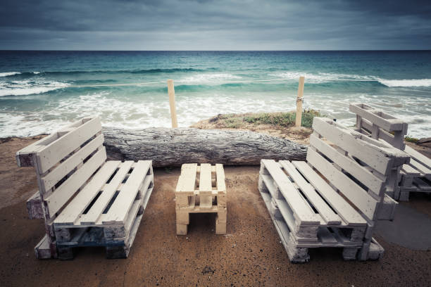 Empty armchair on the deserted beach before the storm, copy space background.