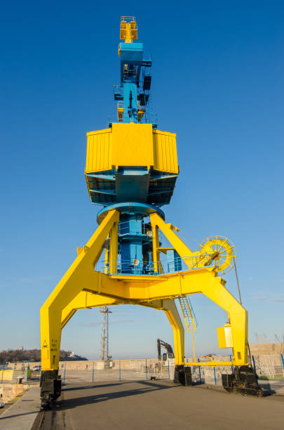 grandes grues travaillant pour décharger un cargo dans le dock - crane hook picking up cargo container photos et images de collection