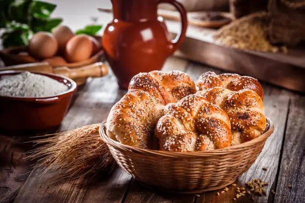 Photo of Buns of bread with sesame and poppy seeds in a wicker basket