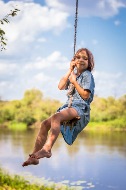 cute girl swinging on the tree - tire swing imagens e fotografias de stock