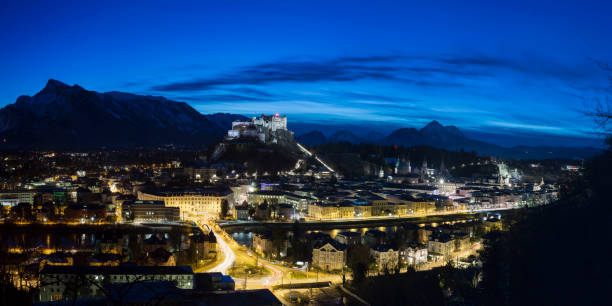 Night Panorama  from Salzburg Night Panorama of the city Salzburg at night with bright blue nightsky . PIcture taken from the mönchsberg. Multipixel Panorama Kapuzinerberg stock pictures, royalty-free photos & images