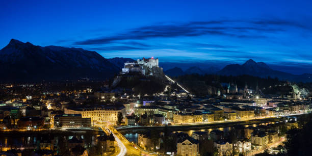 Night Panorama  from Salzburg Night Panorama of the city Salzburg at night with bright blue nightsky . PIcture taken from the mönchsberg. Multipixel Panorama Kapuzinerberg stock pictures, royalty-free photos & images