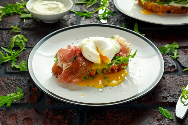 크림 치즈, 와일드 rucola, 파 르 마 햄와 데친된 달걀과 브루 쉐 타 흰색 접시에 봉사 - poached egg 뉴스 사진 이미지