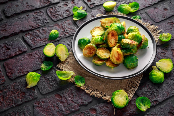 istock Homemade Roasted Brussel Sprouts with Salt, Pepper on a old stone rustic table 900428204