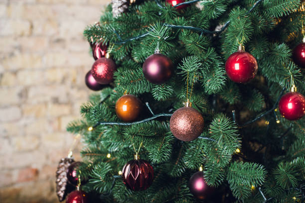 istock Christmas tree with garlands on a brick wall background 900428680