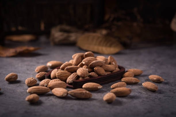 istock Almonds in brown bowl on wooden background 900438508