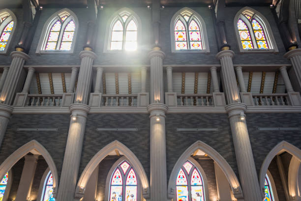 istock Arched columns in monastery chapel with stained glass windows 900439636