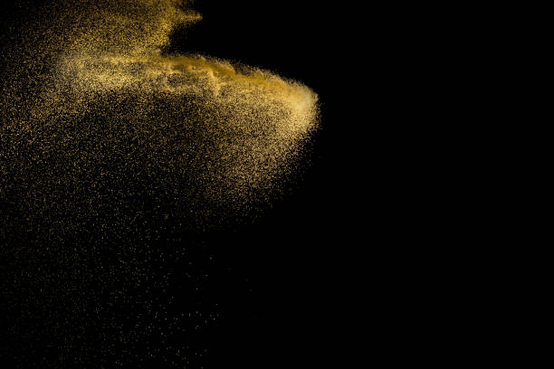 istock Golden sand explosion isolated on black background. Abstract sand cloud. Golden colored  sand splash against  dark background. Yellow sand fly wave in the air. 900454298