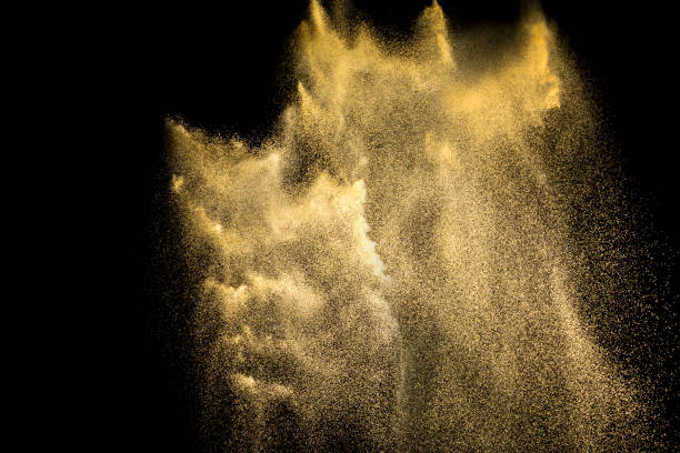 istock Golden sand explosion isolated on black background. Abstract sand cloud. Golden colored  sand splash against  dark background. Yellow sand fly wave in the air. 900454314