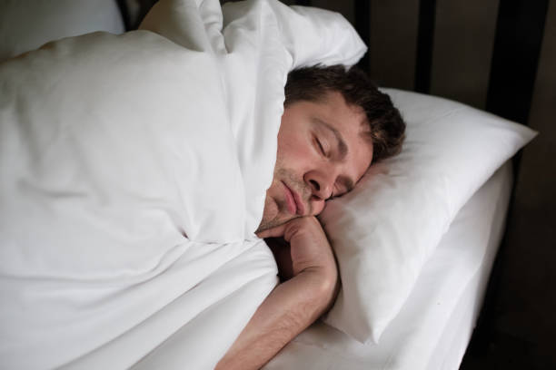 istock Caucasian man sleeping or napping in white bed 900471614