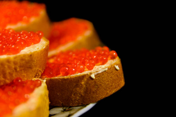 istock Sandwiches with the red caviar isolated on black background 900471906