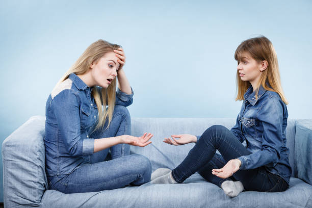 istock Two serious women friends talking on sofa 900479640