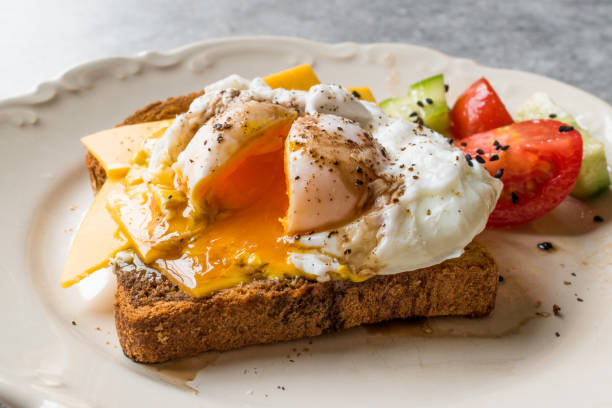 istock Poached Egg on Toast Bread with Cheddar Cheese, Balsamic Vinegar, Salad and Black Sesame or Cumin Seeds 900485944
