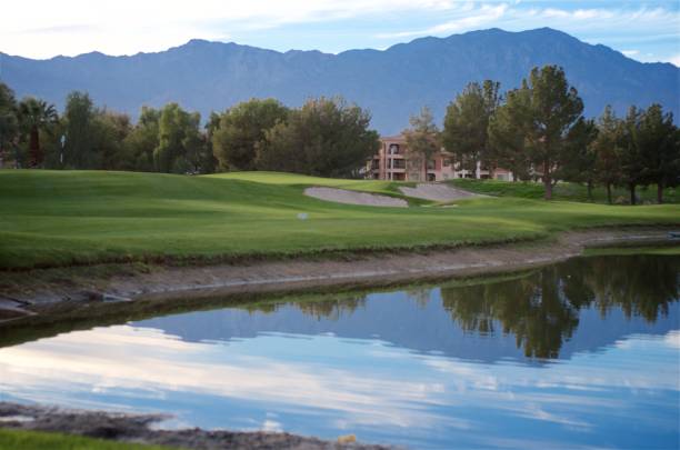 Beautiful Day on the Golf Course Palm Desert resort golf course. Beautiful view of the mountains reflecting on the pond with the green & flag in the background. palm desert pool stock pictures, royalty-free photos & images