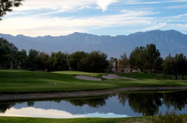 Beautiful Day on the Golf Course Palm Desert resort golf course. Beautiful view of the mountains reflecting on the pond with the green & flag in the background. palm desert pool stock pictures, royalty-free photos & images