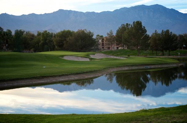 Beautiful Day on the Golf Course Palm Desert resort golf course. Beautiful view of the mountains reflecting on the pond with the green & flag in the background. palm desert pool stock pictures, royalty-free photos & images