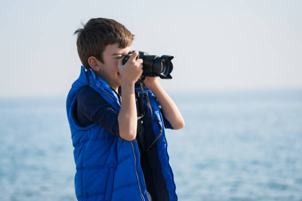 istock Happy  photographer Boy walking on the beach on a Winter's Day 900489420
