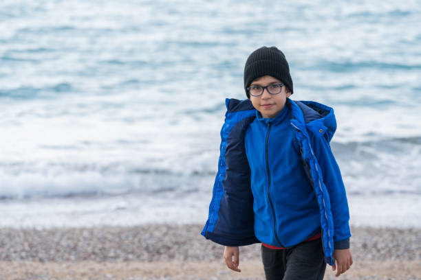 Happy  Boy walking on the beach on a Winter's Day