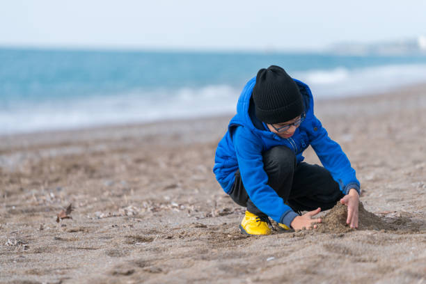 istock Happy  Boy Playing in the Sand on a Winter's Day 900503350