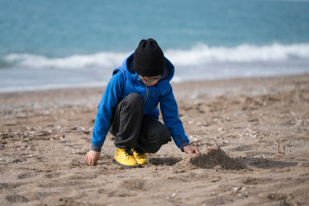 Happy  Boy Playing in the Sand on a Winter's Day