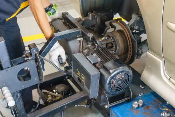 Brake disc grinding machine - Vehicle brake-disc turning machine. Automobile disc brake system repair in garage.
