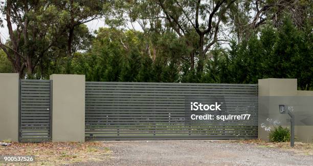 Metal Driveway Entrance Gates Set In Brick Fence Leading To Rural Property With Eucalyptus Trees In Background Stock Photo - Download Image Now