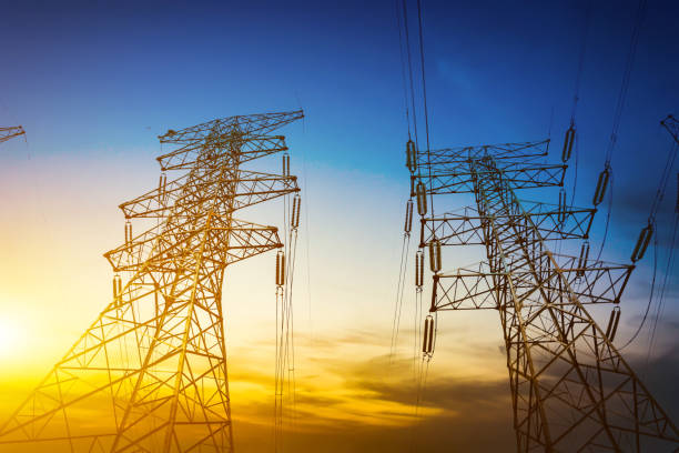 istock Sun setting behind the silhouette of electricity pylons 900544092