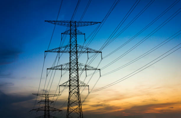 istock Sun setting behind the silhouette of electricity pylons 900544094
