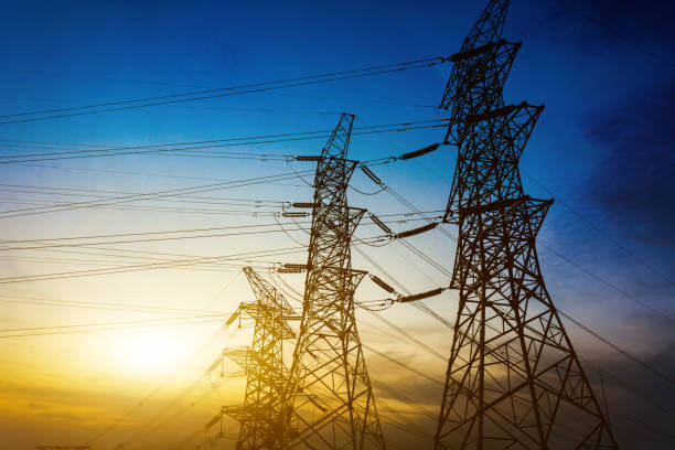 istock Sun setting behind the silhouette of electricity pylons 900544106