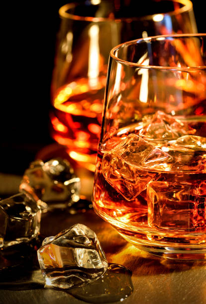 istock Two glasses of whiskey with ice on a black background 900561914