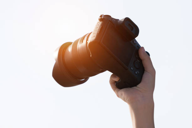 istock Child holds a Dslr photo camera sky background. 900564956