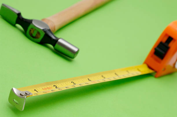 istock hammer tape measure work mans tools against green 90056796